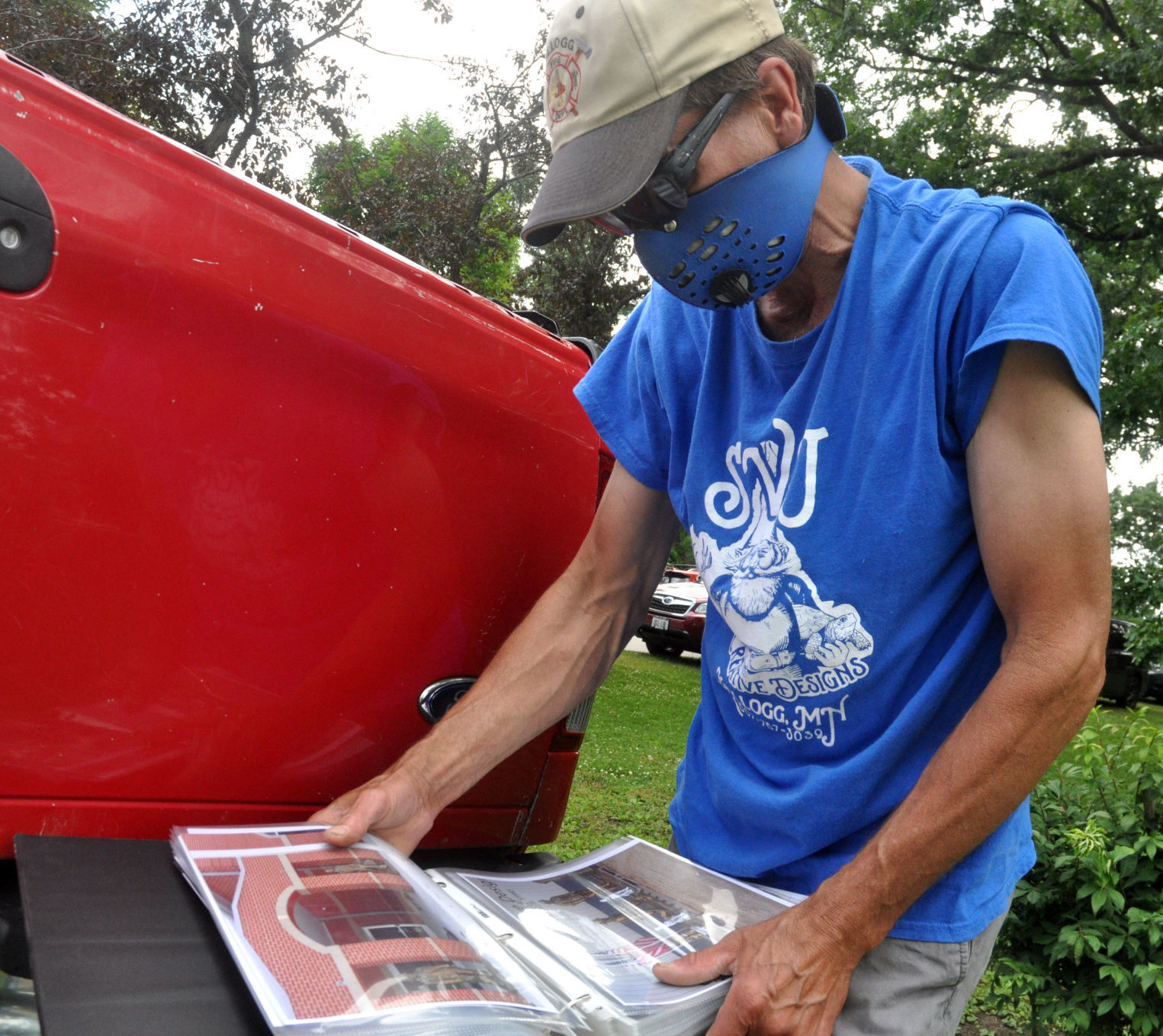 David Speedling, co-owner of SVJ Creative Designs, shows photographs of some of the statues